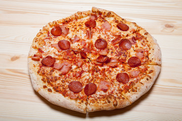 Fresh homemade pizza on light wooden table