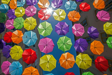 Fototapeta na wymiar Background with colored umbrellas on one street in Timisoara