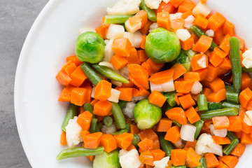 Fresh vegetables mix in a white bowl.