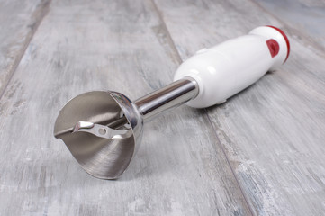 Electric hand blender isolated on the reclaimed oak background