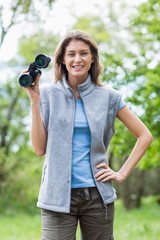 Portrait of young woman holding binocular 