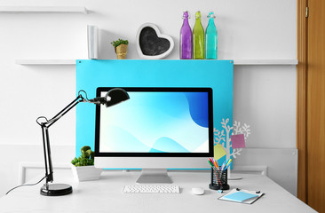 Stylish workplace with computer and interior decorations