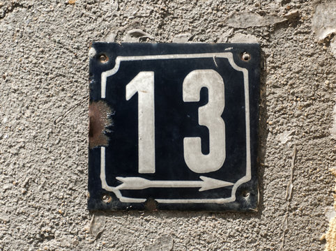 Old retro weathered cast iron plate with number 13