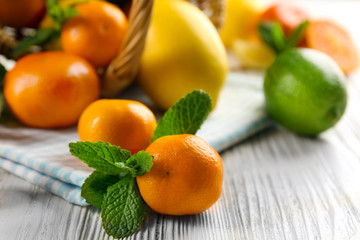 Set of different citrus fruit on light wooden table