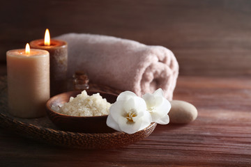 Spa set with sea salt, exotic flowers and candles on wicker tray