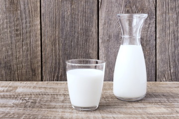 the glass and the bottle of milk on the old table