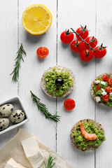 Avocado sandwiches with vegetables on wooden background