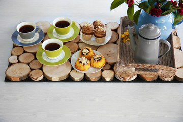 Table setting with tea and cakes on wooden background