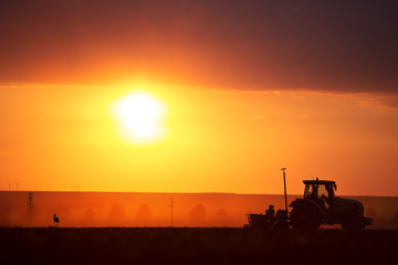 Obraz premium Farmer in tractor preparing land with seedbed cultivator