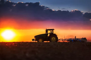 Crédence de cuisine en verre imprimé Tracteur Agriculteur en tracteur préparant la terre avec cultivateur de lit de semence
