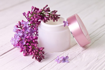 Pot of moisturizing cream with lilac flowers