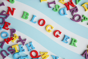 Word BLOGGER made with colorful letters on striped background