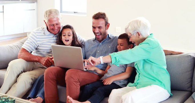 Happy multi generation family using laptop