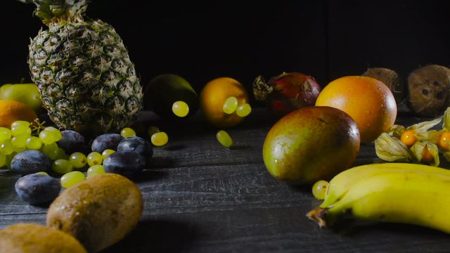 Grapes Falling on Wooden Table With Tropical Fruits