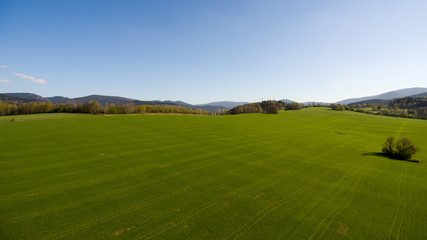 Aerial View. Panorama over a green grassy in mountains.