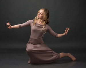 Contemporary dance. Beautiful elegant woman dances on gray background