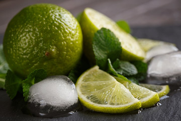Fresh lime, mint and ice cubes. Dark background