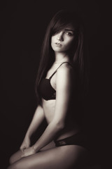 Naklejka premium Shot of a sexy woman in black lingerie over black background.