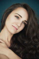 Naklejka premium Beautiful young woman with big eyes and curly hair smiling. Beau