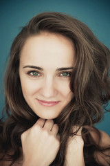 Naklejka premium Beautiful young woman with big eyes and curly hair smiling. Beau
