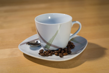 Empty Cup on a saucer with coffee beans