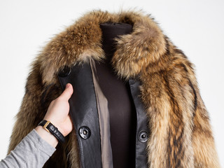 Man's hand touching a fur coat