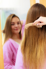 Naklejka premium Woman combing her long hair in bathroom