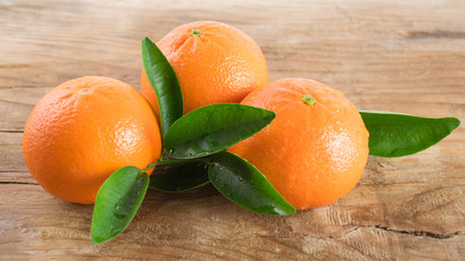 Three mandarins orange (tangerines) on wooden background