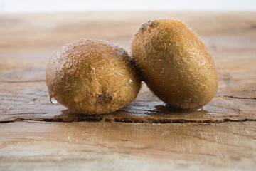 Two kiwi on wooden background