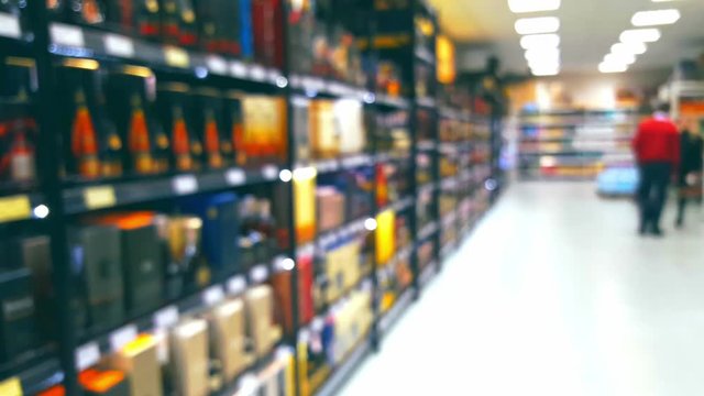 Supermarket interior with buyers, Liquor department,  blurred defocused background