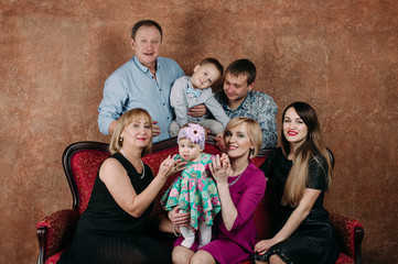 Three Generation Family Sitting On Sofa Together. Classic portrait