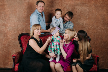 Three Generation Family Sitting On Sofa Together. Classic portrait