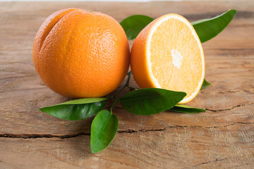 Oranges fruit with leaves on wooden background