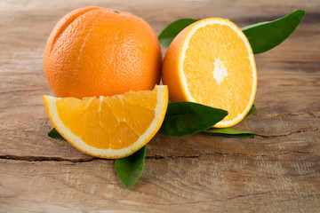 Oranges fruit with leaves on wooden background