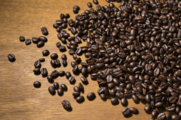 Coffee beans spilling on a wood table