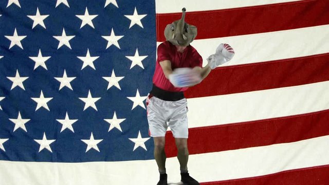 Man in elephant GOP mask doing a victory dance against against an American Flag.