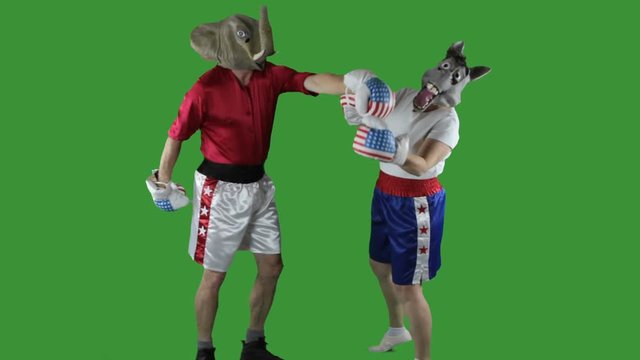 Man in elephant GOP mask delivering a knock-out punch to a woman in donkey Democrat mask against a green screen .