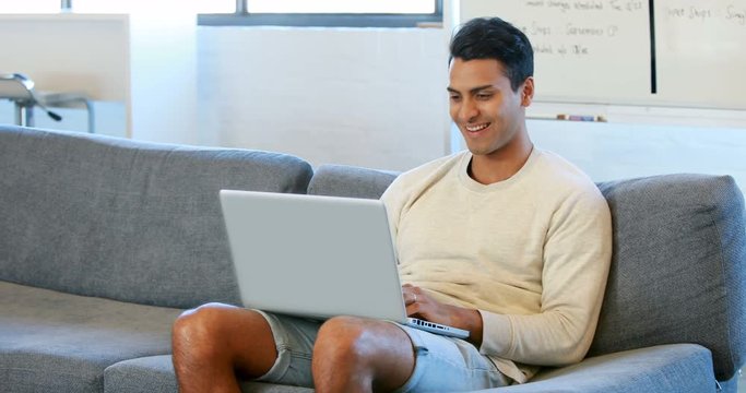 Man using a laptop sitting on the couch
