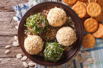 Cottage cheese balls with crackers, herbs and pumpkin seeds close-up. horizontal top view
