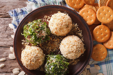 Cheese balls with crackers, herbs and seeds close-up. horizontal top view
