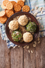 Goat Cheese balls with crackers, herbs and pumpkin seeds. vertical view from above
