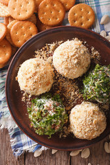 Cheese balls with crackers, herbs and seeds close-up. vertical top view
