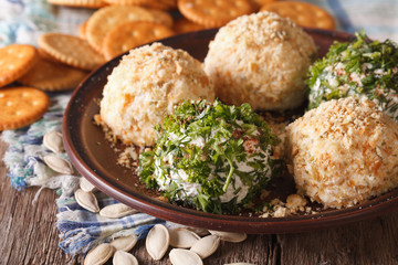 Healthy snacks: Cheese balls with crackers, herbs and seeds close-up. horizontal
