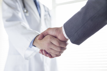 握手する医師とビジネスマンの手