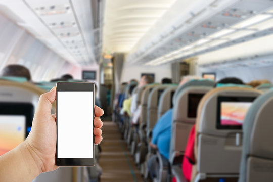 hand holding mobile phone on Airplane interior blur background