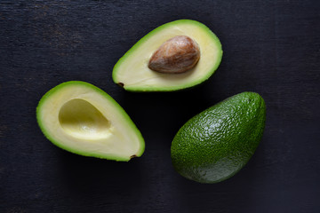 Fresh, raw avocado on a black background, top view