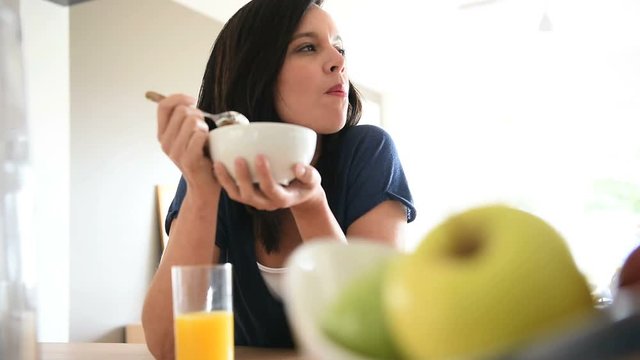 Mature woman eating cereals for breakfast