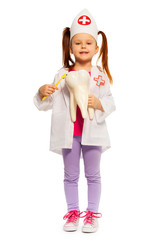 Cute little dentist brushing big tooth dummy