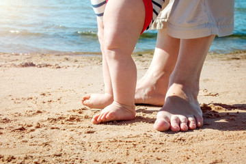 Obraz na płótnie Canvas Nine month old baby boy walking on the beach in beautiful summer day