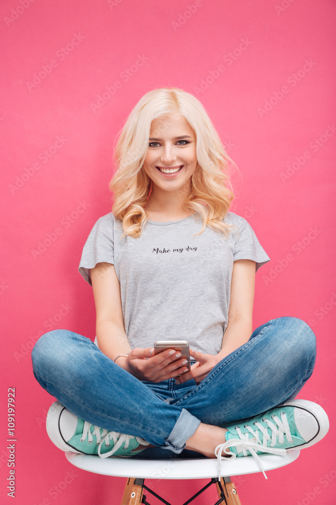 Canvas Prints Woman sitting on the chair and holding smartphone